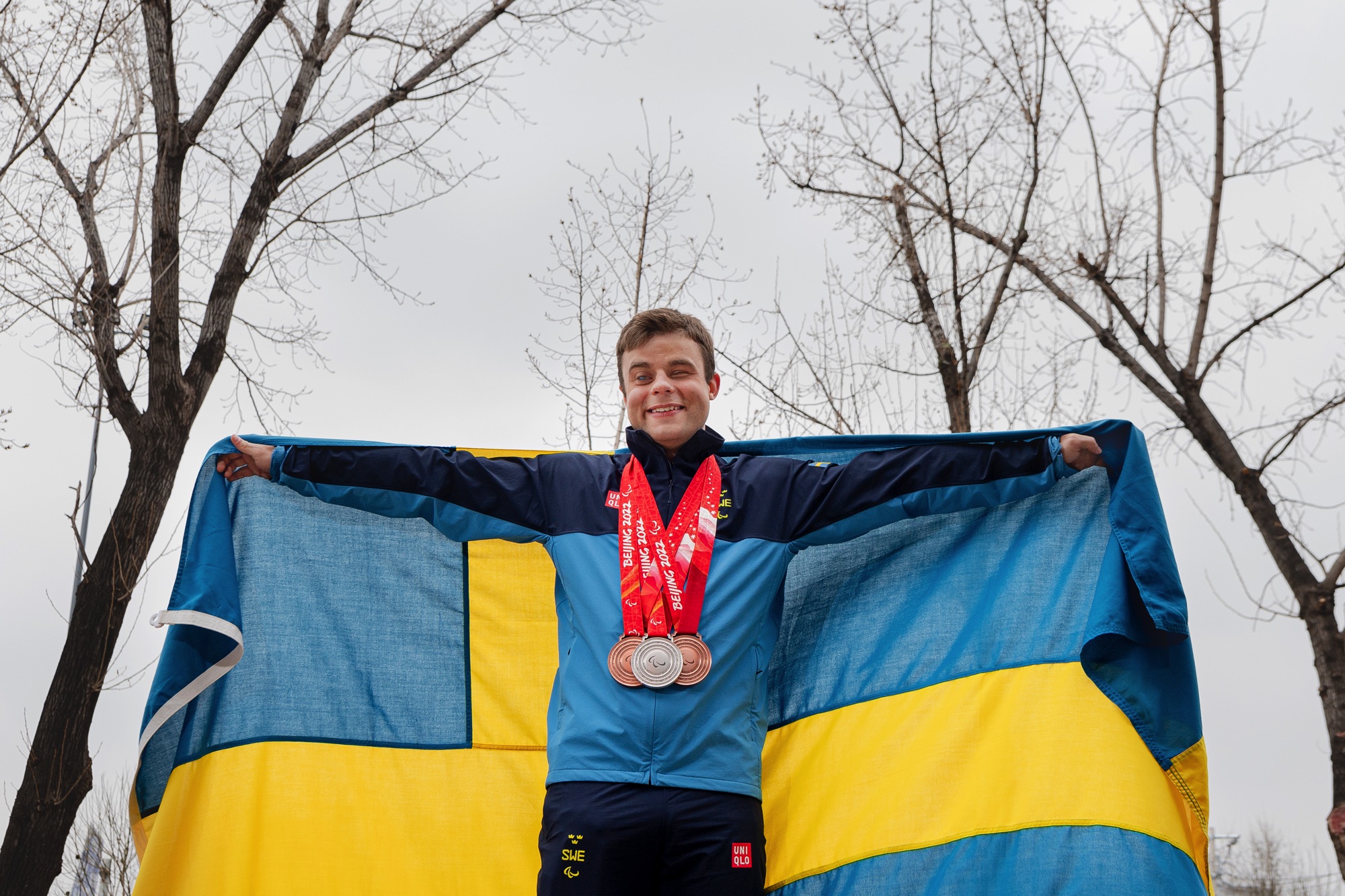Zebastian Modin var fanbärare för Sverige, här står han med svenska flaggan och ler.
