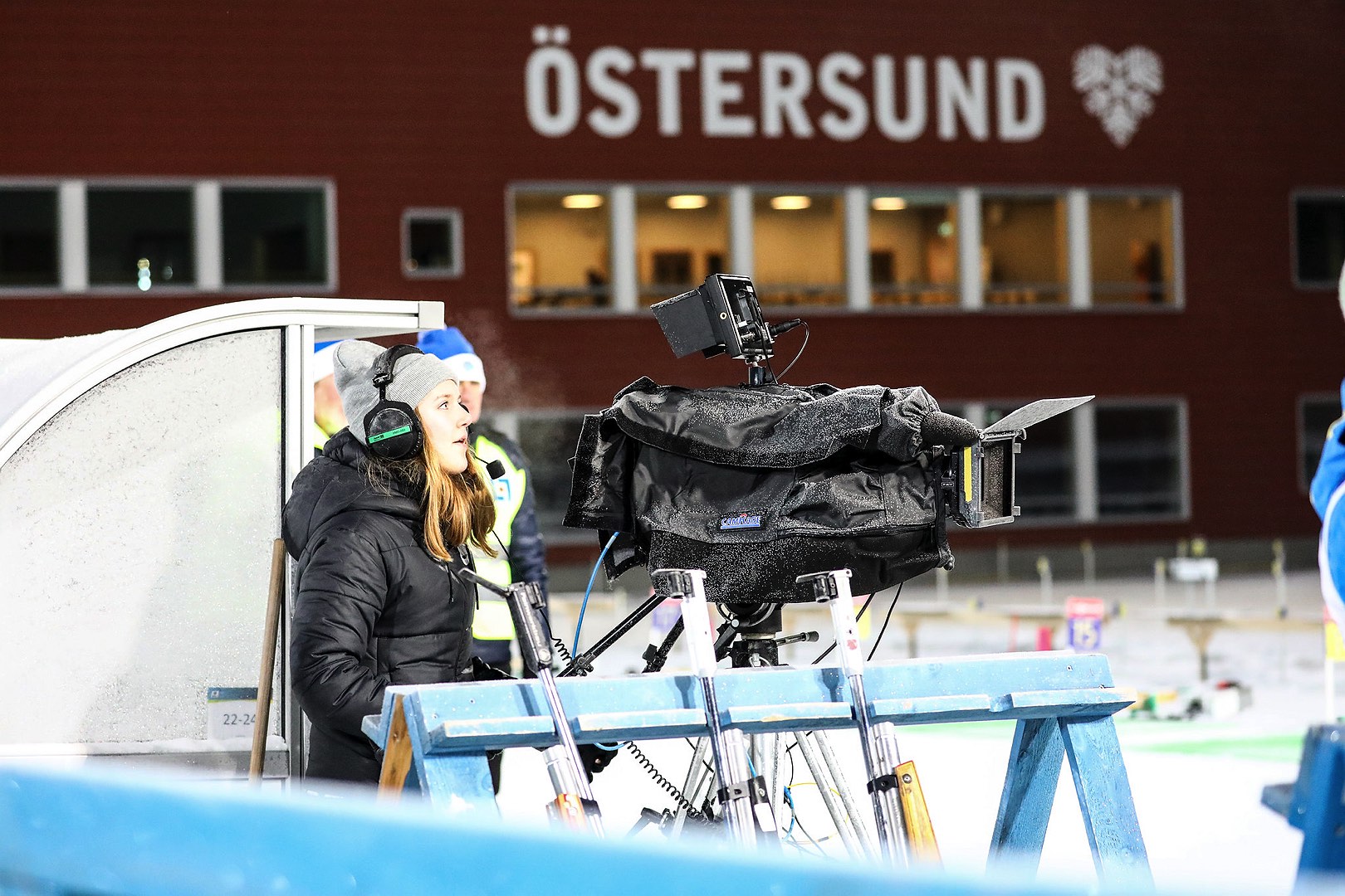 En kvinna sköter en tv-kamera i samband med en tävling på Östersunds skidstadion.
